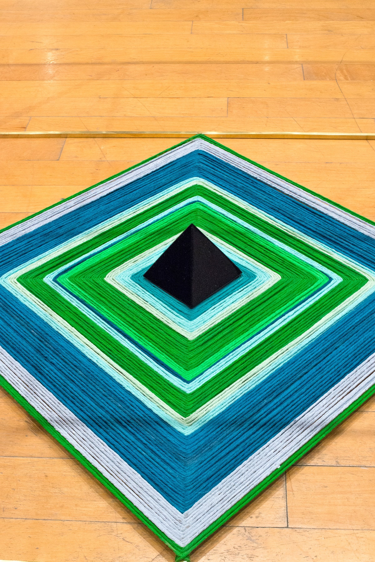 Geometric installation made of green, blue and white yarn
